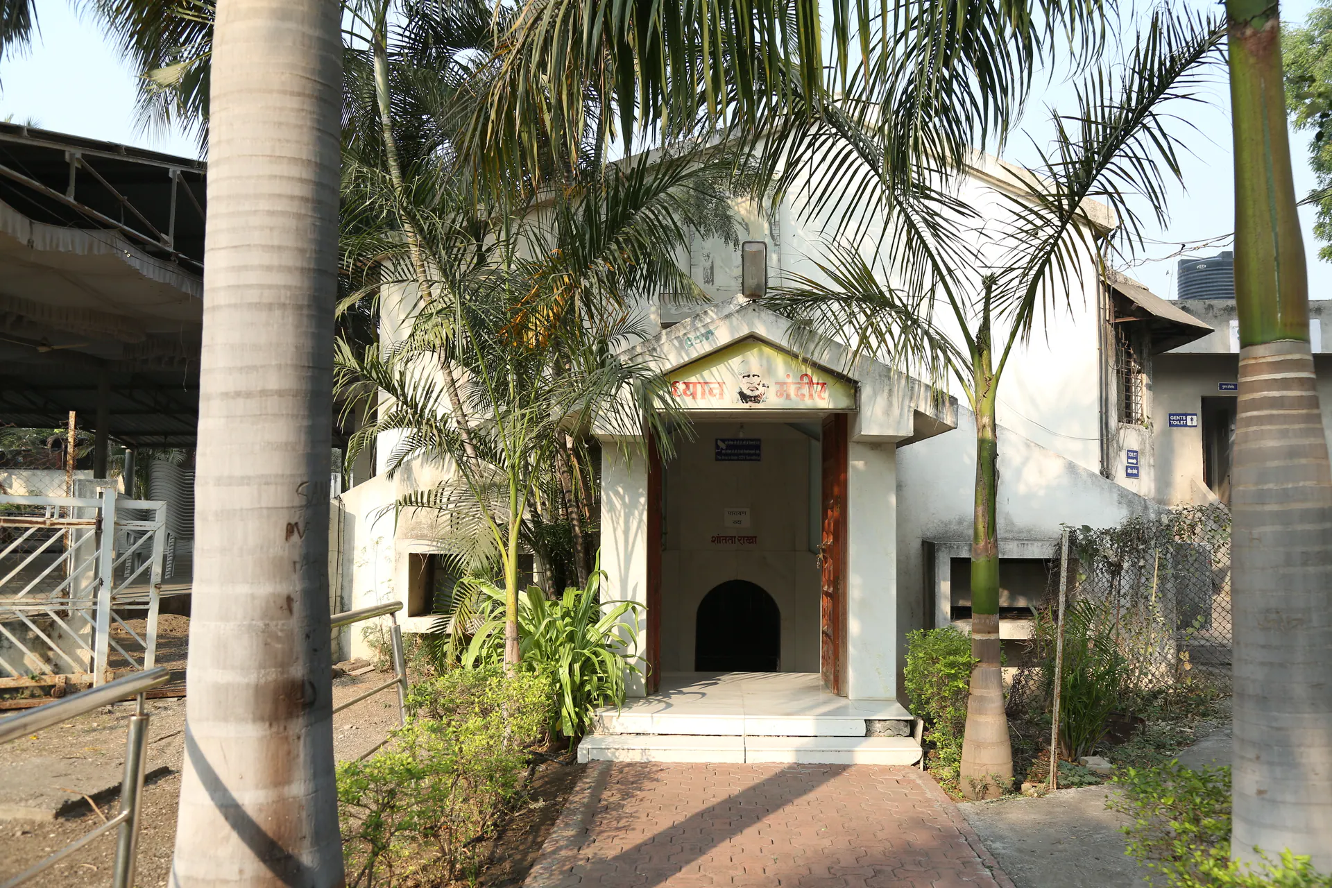 Dhyan Mandir entrance surrounded by palm trees and garden paths