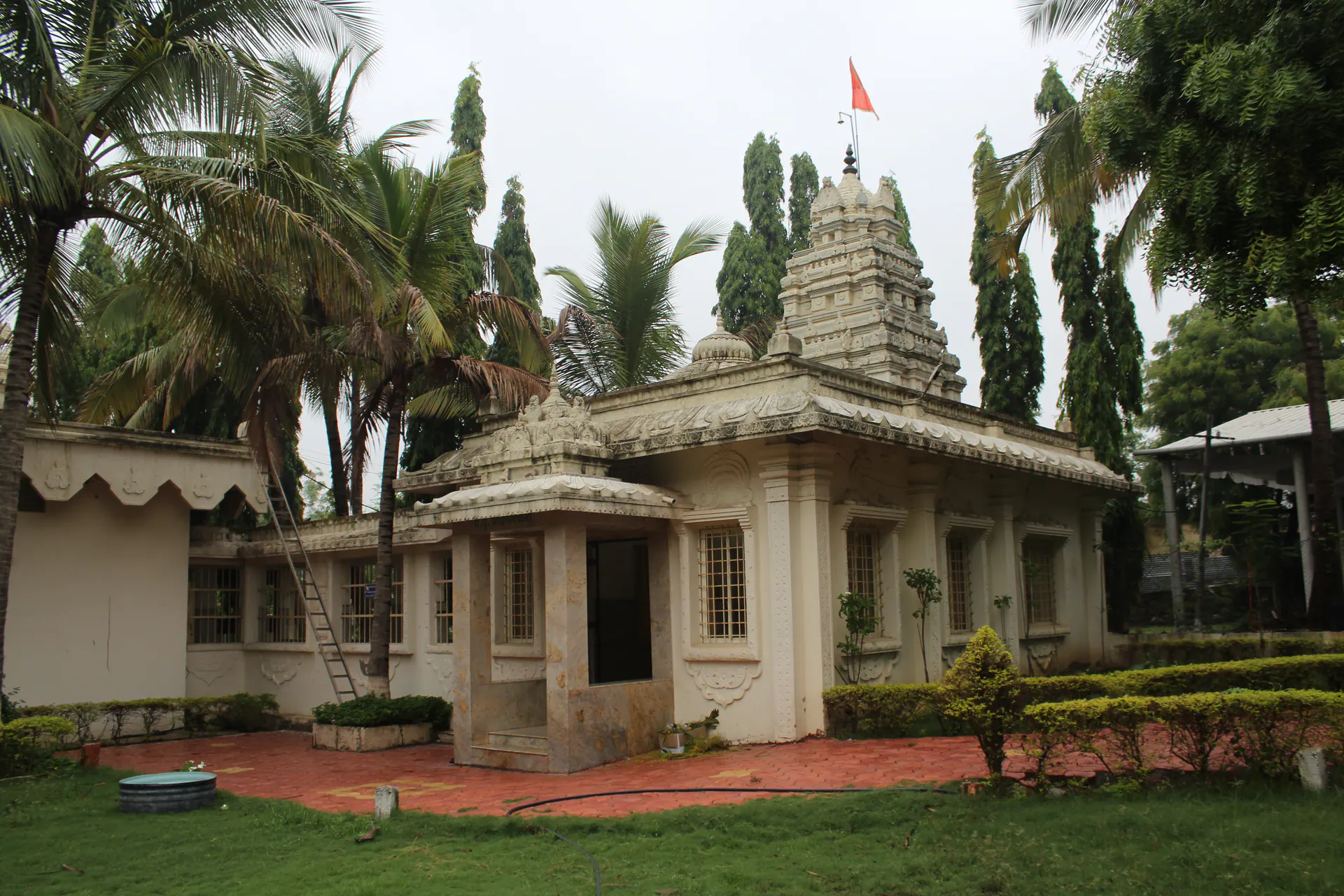 A small white temple structure within the Saidham Mandir campus